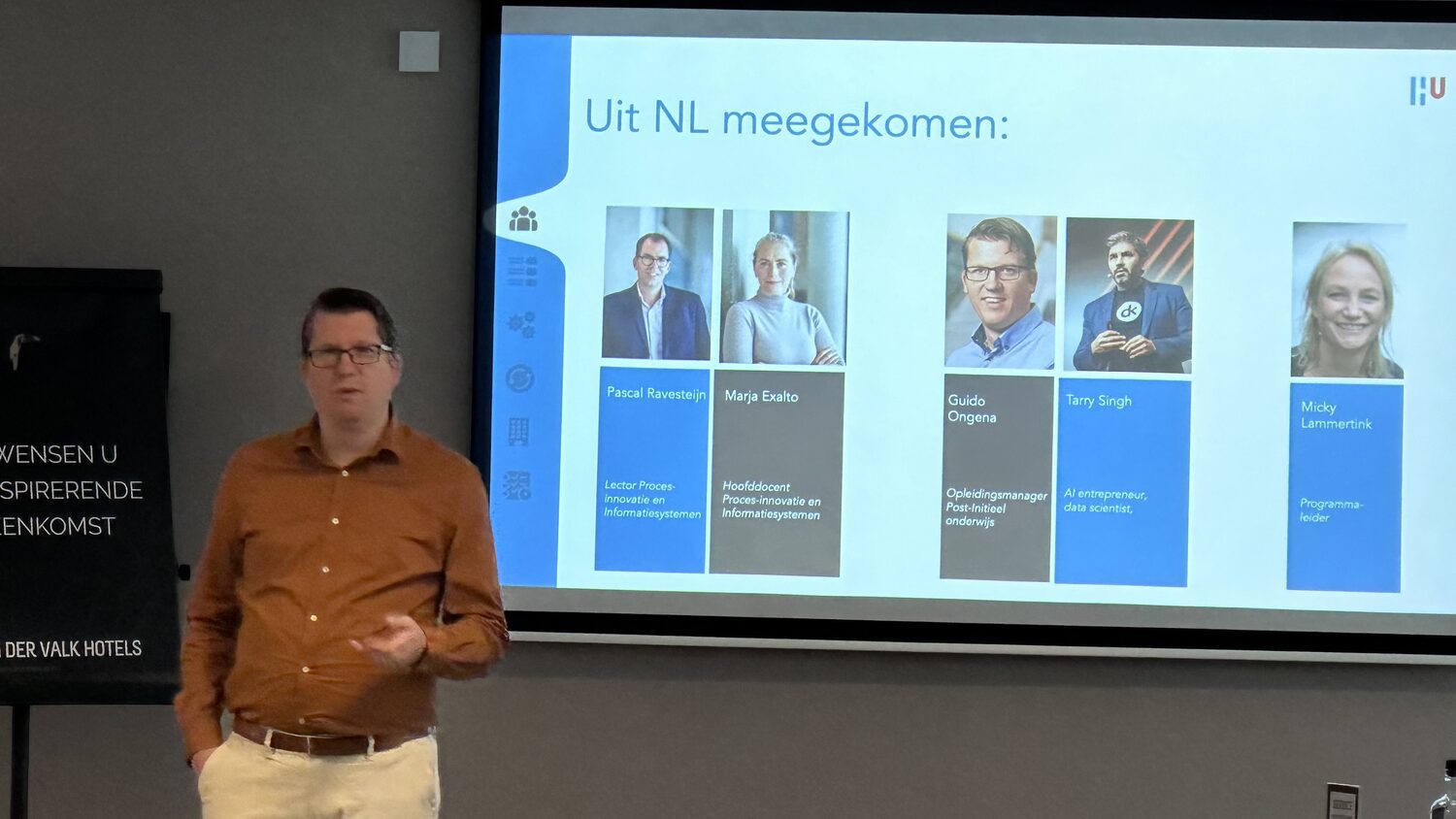 A presenter beside a slide headed Uit NL meegekomen showing five portraits of the Hogeschool Utrecht party and their roles.
