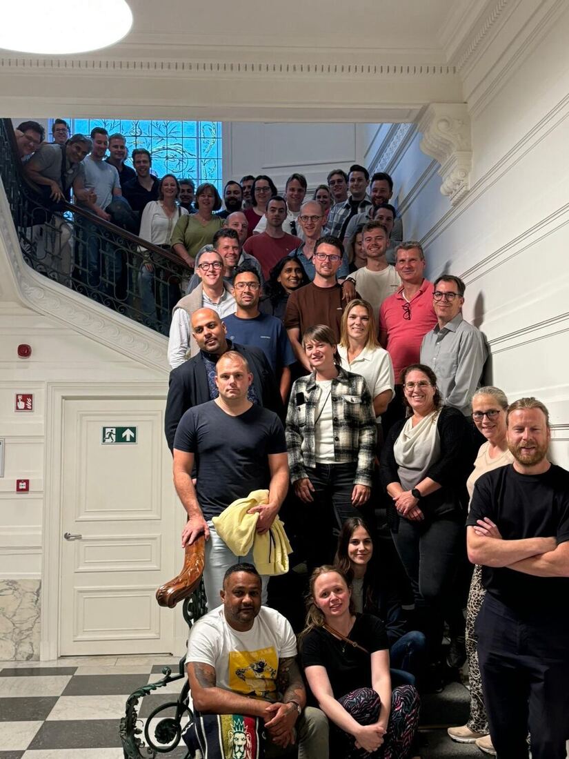 The full cohort gathered on an ornate staircase for a group photograph.