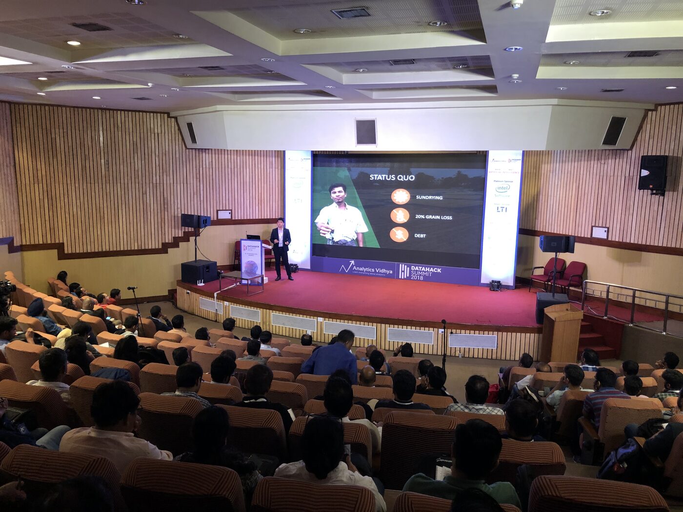 The DataHack Summit 2018 main auditorium at the NIMHANS Convention Centre seen from the balcony, a full house facing the stage and screen.