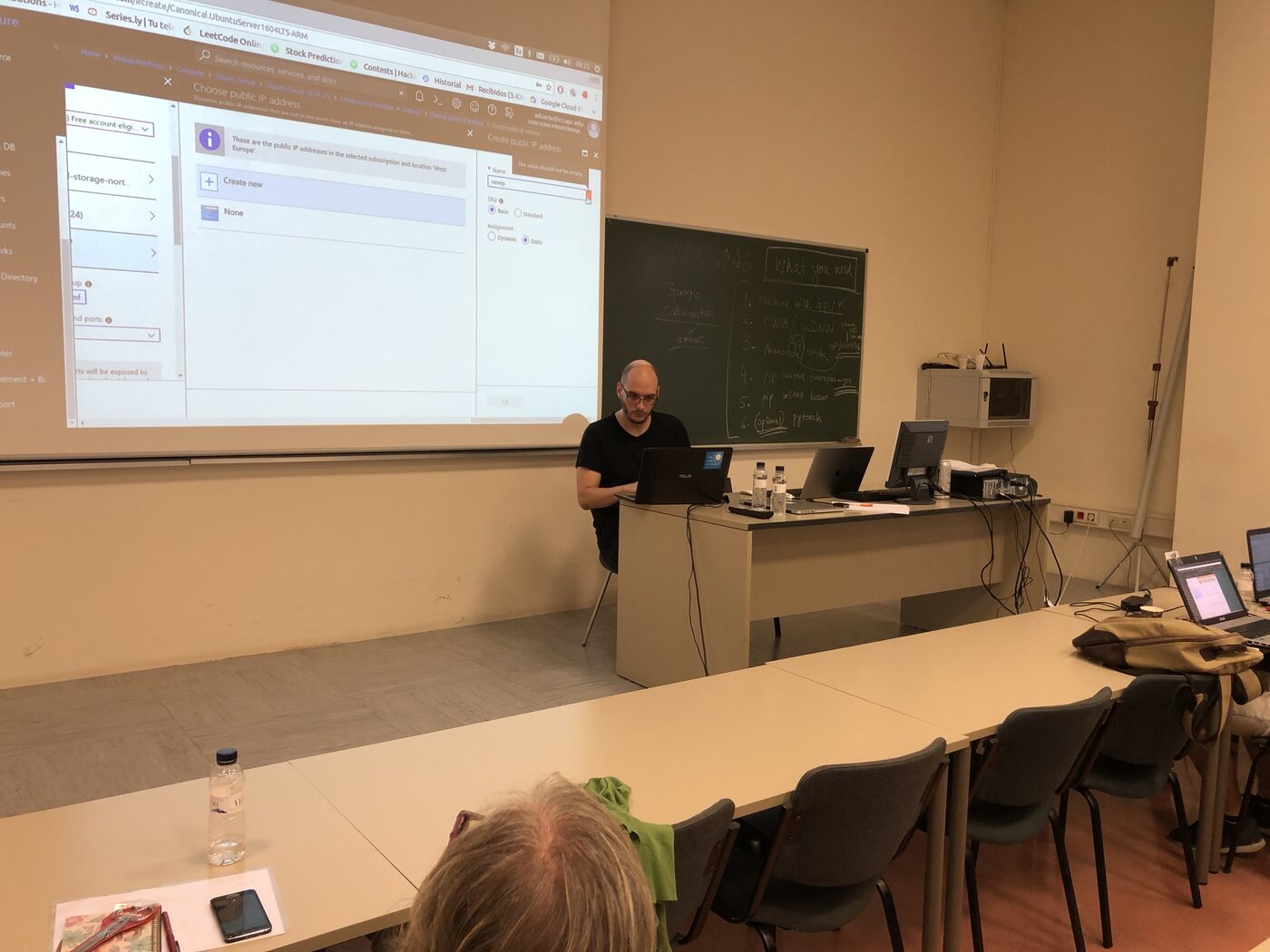 The instructor at the chalkboard with the day one setup checklist written up: a GPU machine, CUDA and cuDNN, Anaconda, tensorflow-gpu, keras, pytorch optional. The Azure portal is projected beside it.