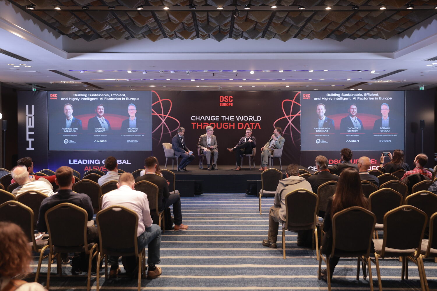 A full main hall at DSC Europe seen from the back, four panellists on stage under the title Building Sustainable, Efficient, and Highly Intelligent AI Factories in Europe