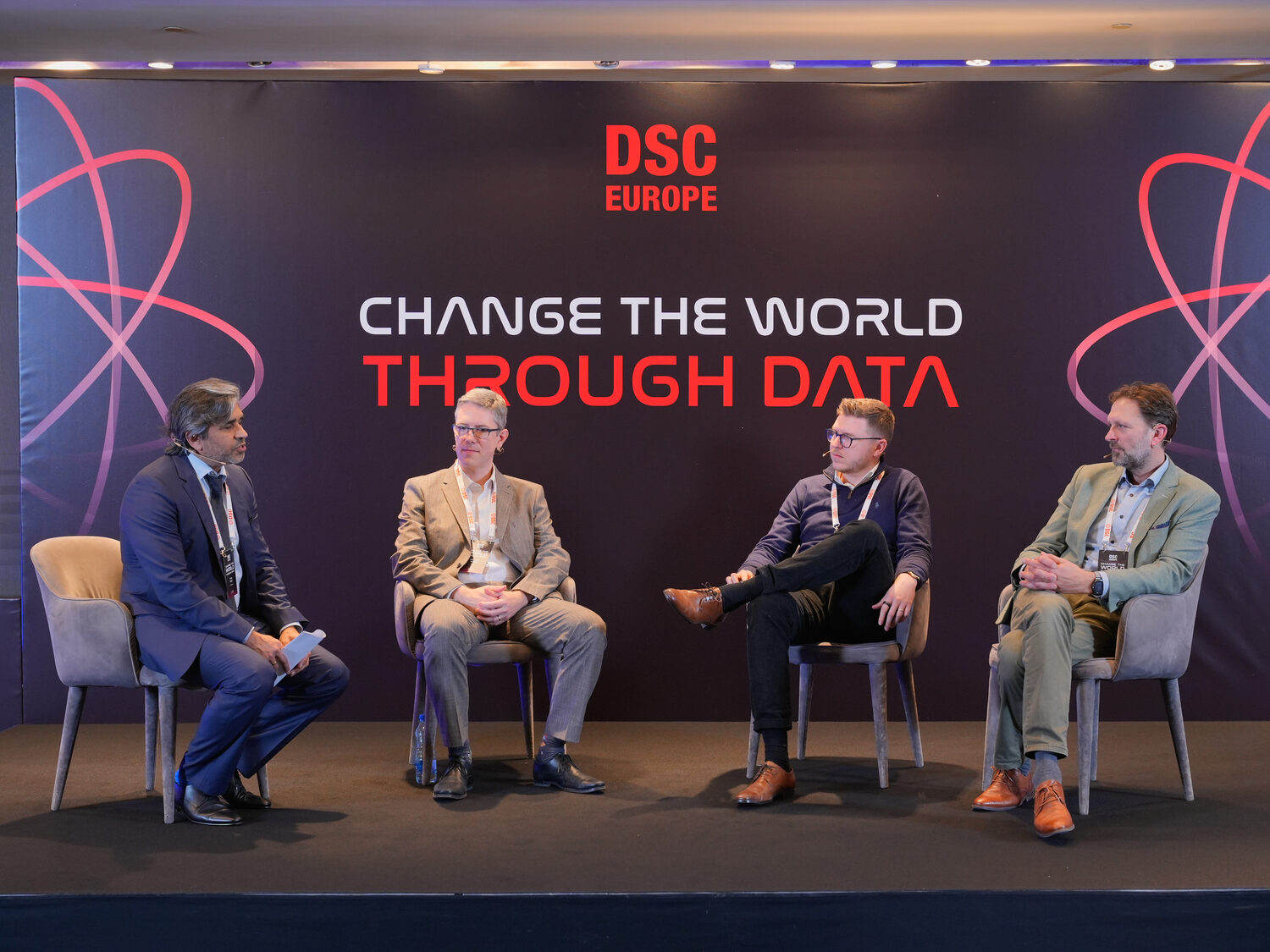 Four panellists seated on the main stage beneath the words Change the world through data