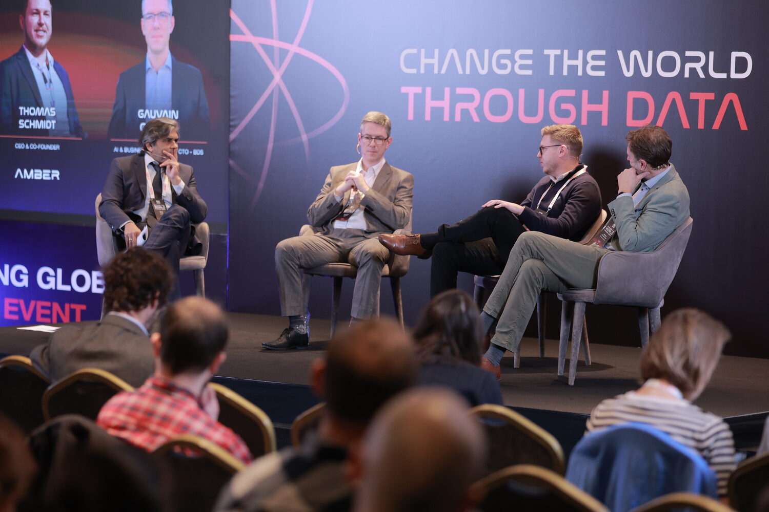 A panel underway on the main stage, the side screen naming Thomas Schmidt, CEO and co-founder of Amber, with the audience in the foreground