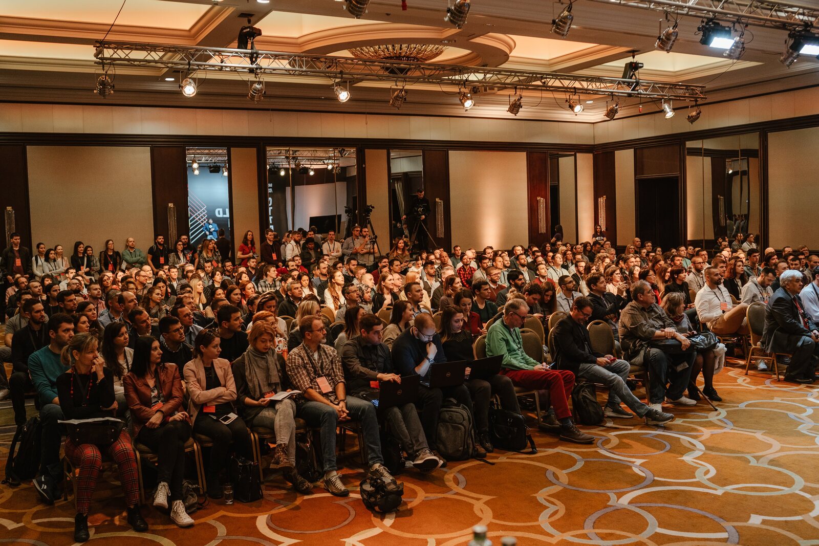 The conference ballroom from the side of the stage, every seat taken and delegates standing along the back wall.