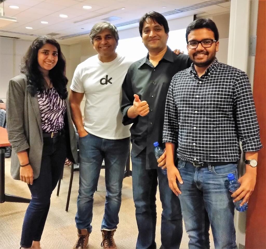 Four participants standing with Tarry Singh at the side of the workshop room.
