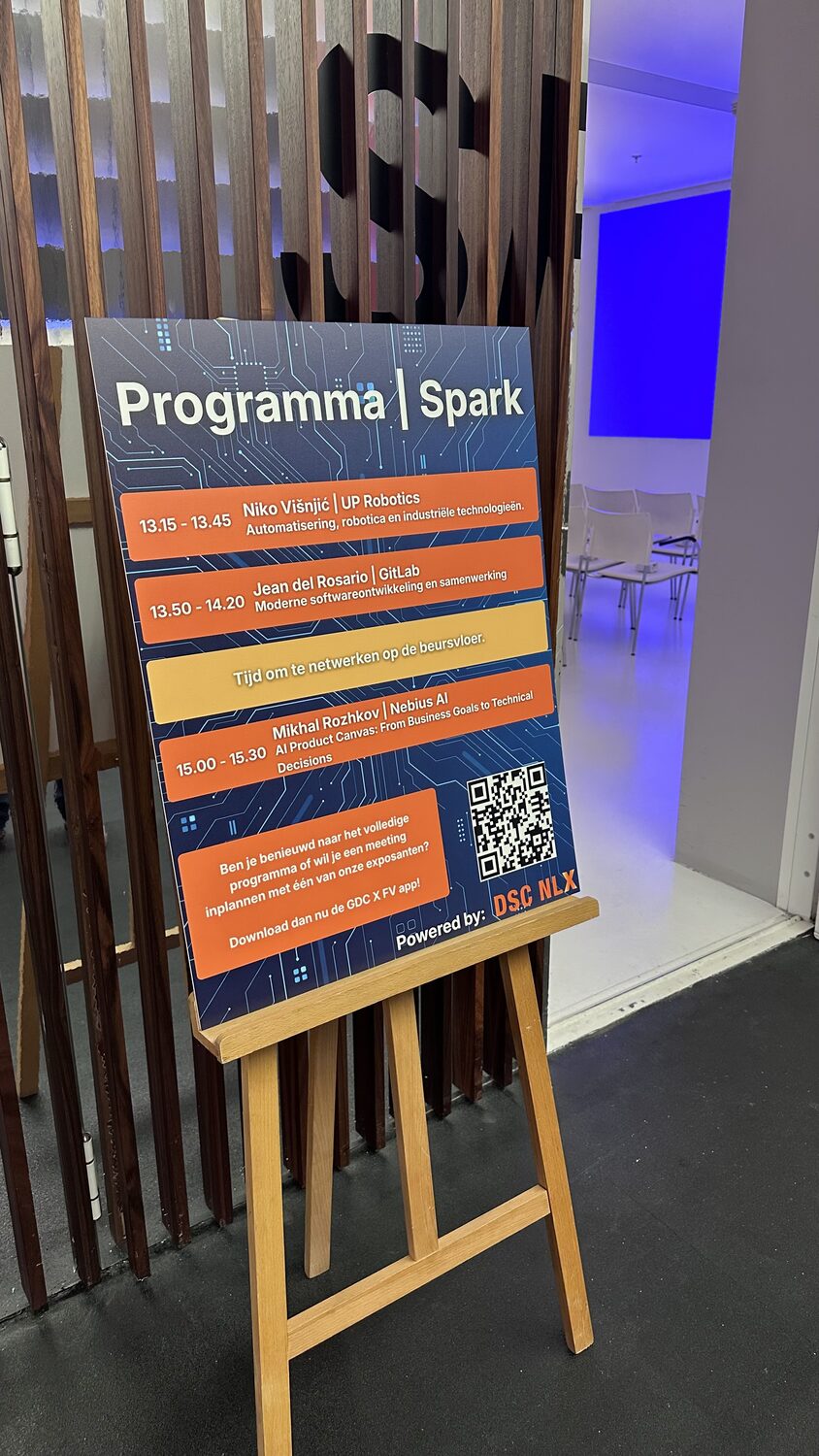 The Programma Spark board on a wooden easel, three afternoon sessions listed, powered by DSC NLX printed at the foot.