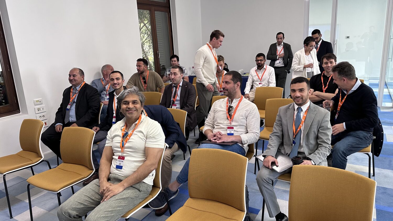A closed session in Cairo on 10 April 2025, delegates seated on stacking chairs wearing orange lanyards and visitor badges.