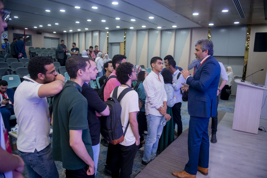 A queue of students waiting to speak with Tarry Singh at the front of the hall after his talk.