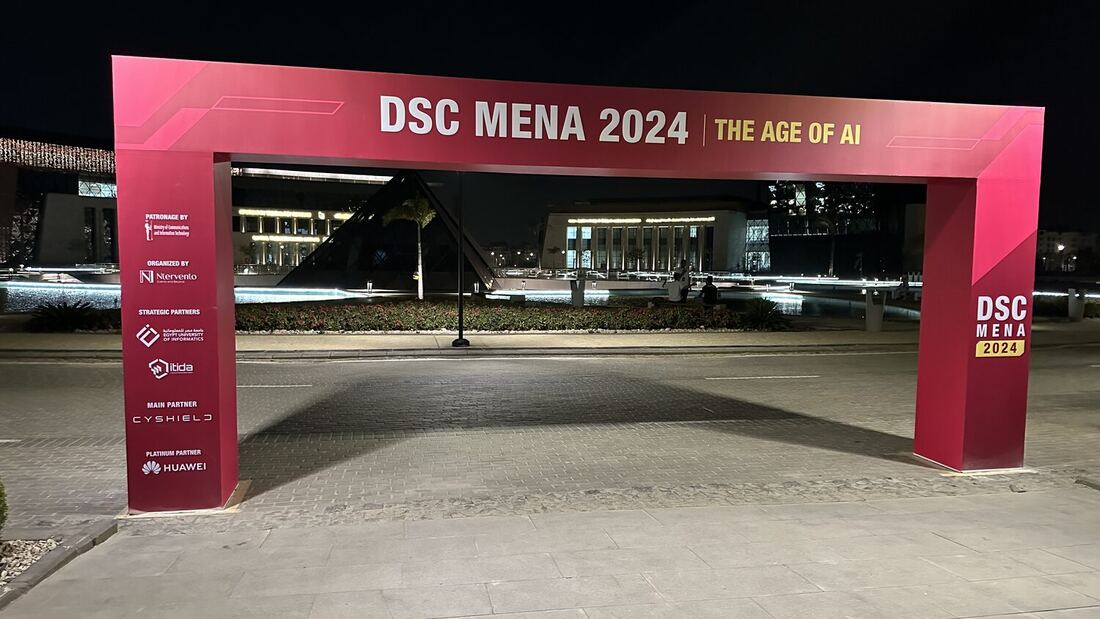 The DSC MENA 2024 The Age of AI entrance arch lit at night in front of the New Administrative Capital.