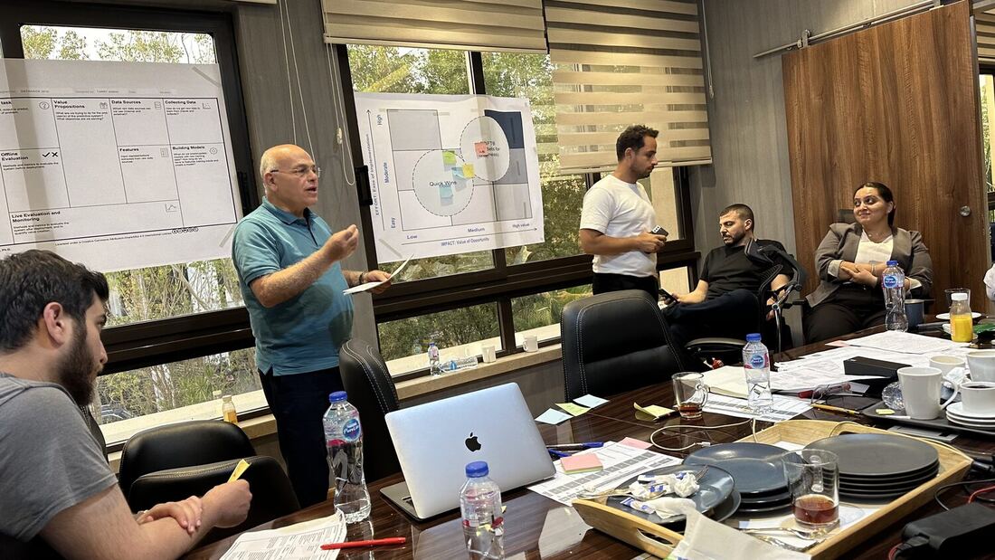 Participant presenting back to the boardroom in front of the Data Science Canvas and the prioritisation grid