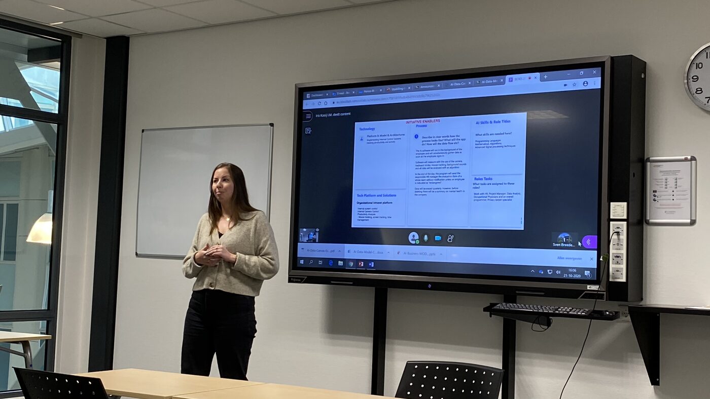 Close view of the room display. A shared canvas headed Initiative Enablers is on screen, with columns for process, technology, AI skills and role titles, and roles tasks. The taskbar clock reads 21-10-2020, 16:06.