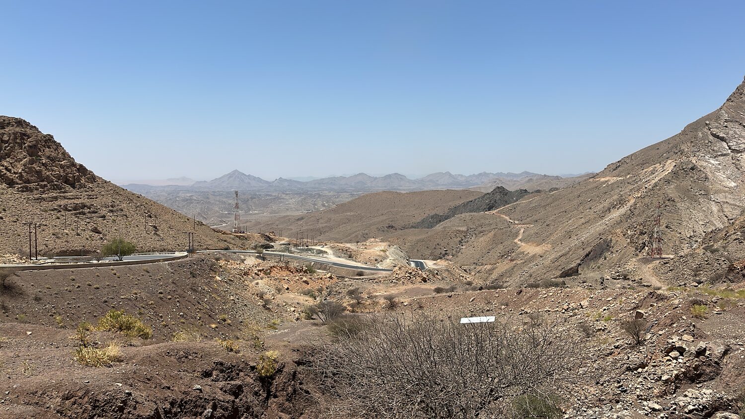The arid Hajar range outside Muscat, bare rock and scree running back in ridges.