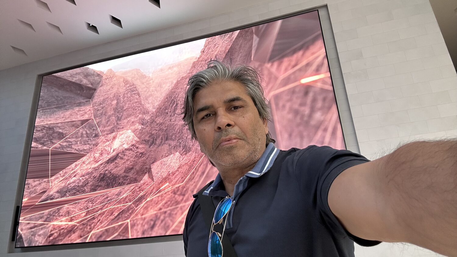 Standing in front of the subsurface visualisation screen, the reservoir model lit in red behind.