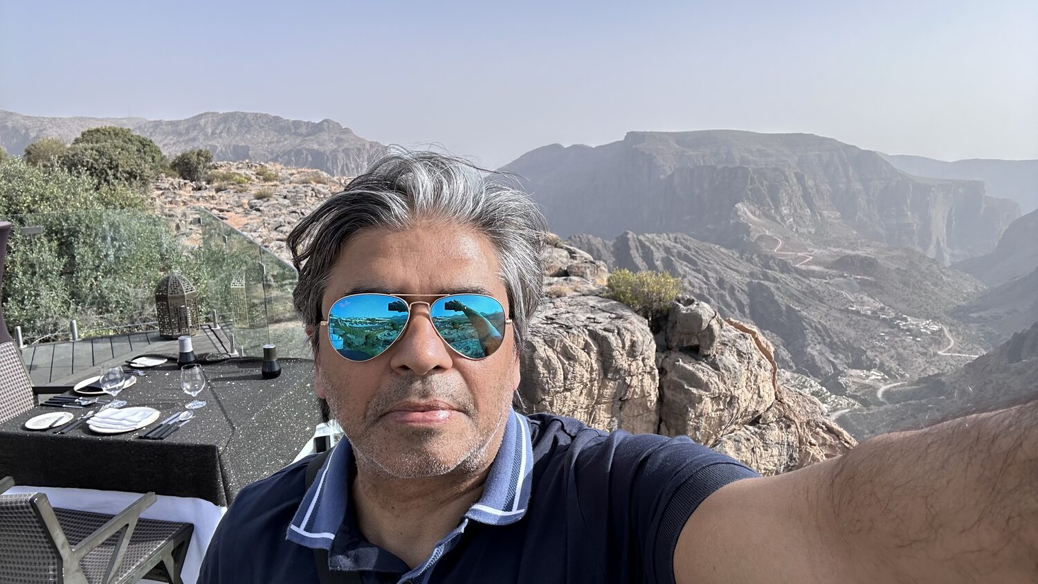 On a viewpoint above the Hajar mountains, the folded ridges running away behind.