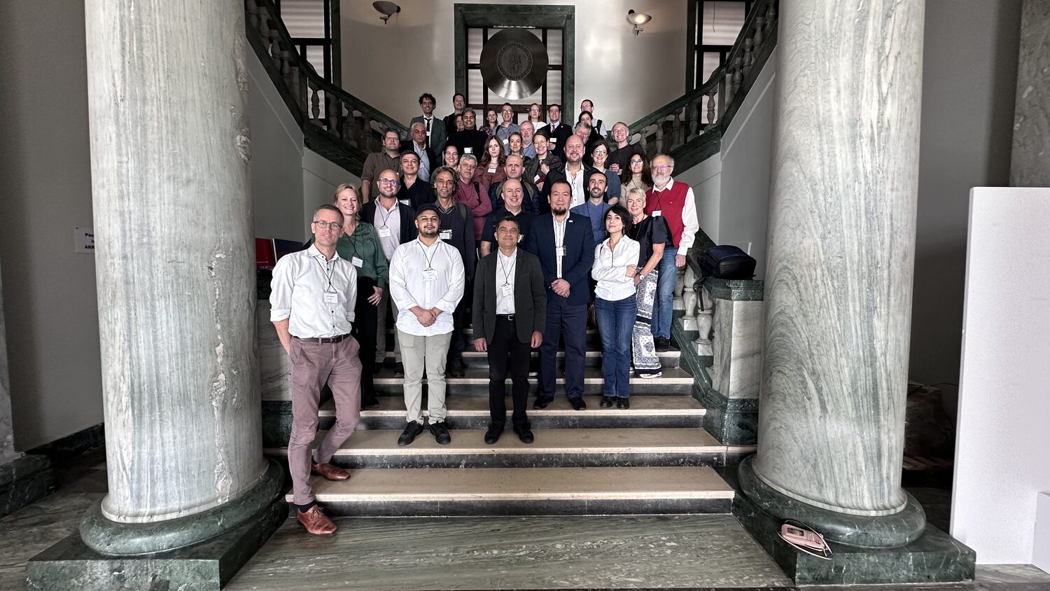 Around forty PANORAIMA partners on the marble entrance staircase of the University of Naples Federico II, beneath the bronze seal of Frederick II.