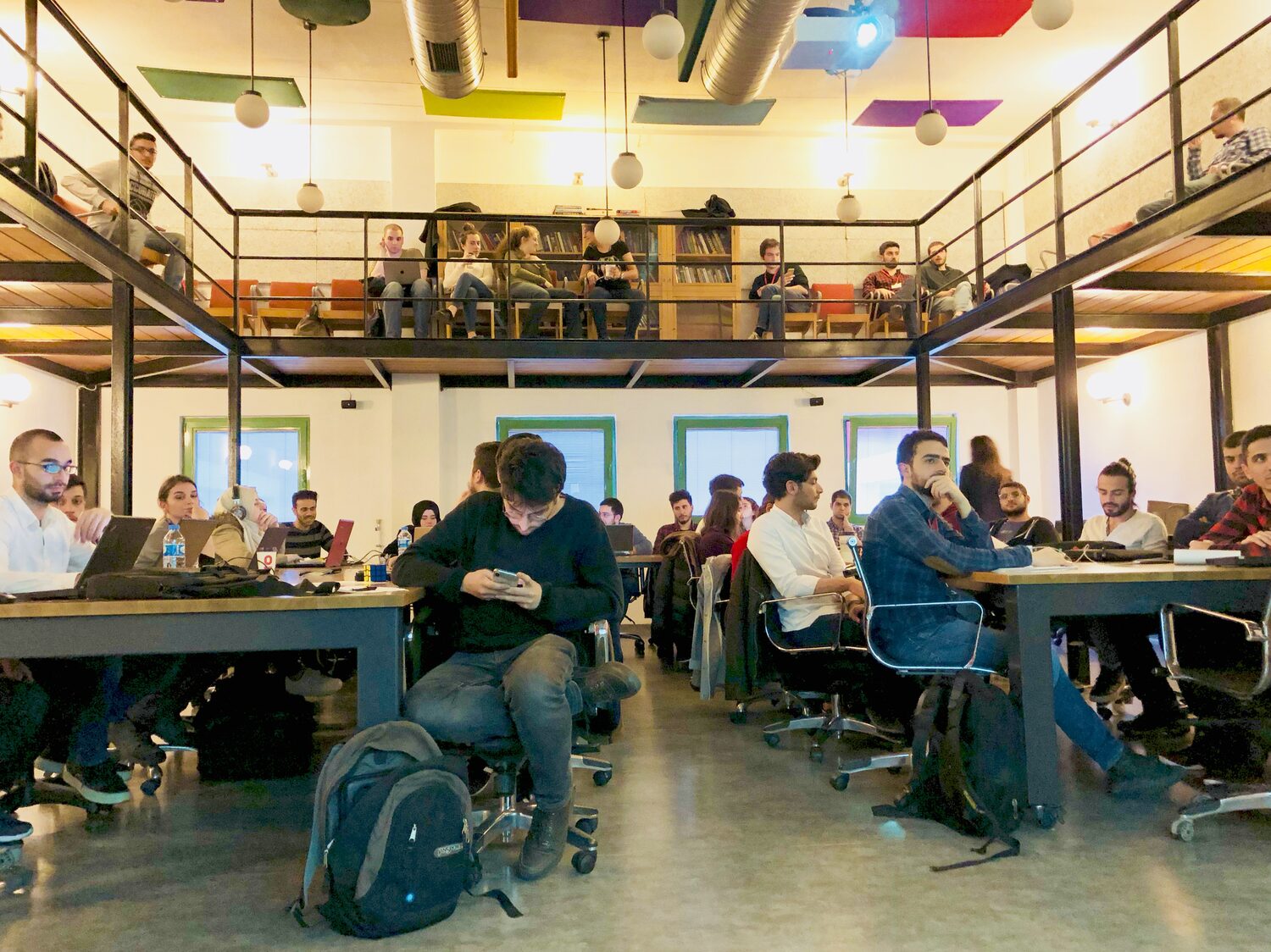 The Istanbul workshop room on two levels, laptops open along shared desks with more people watching from the mezzanine