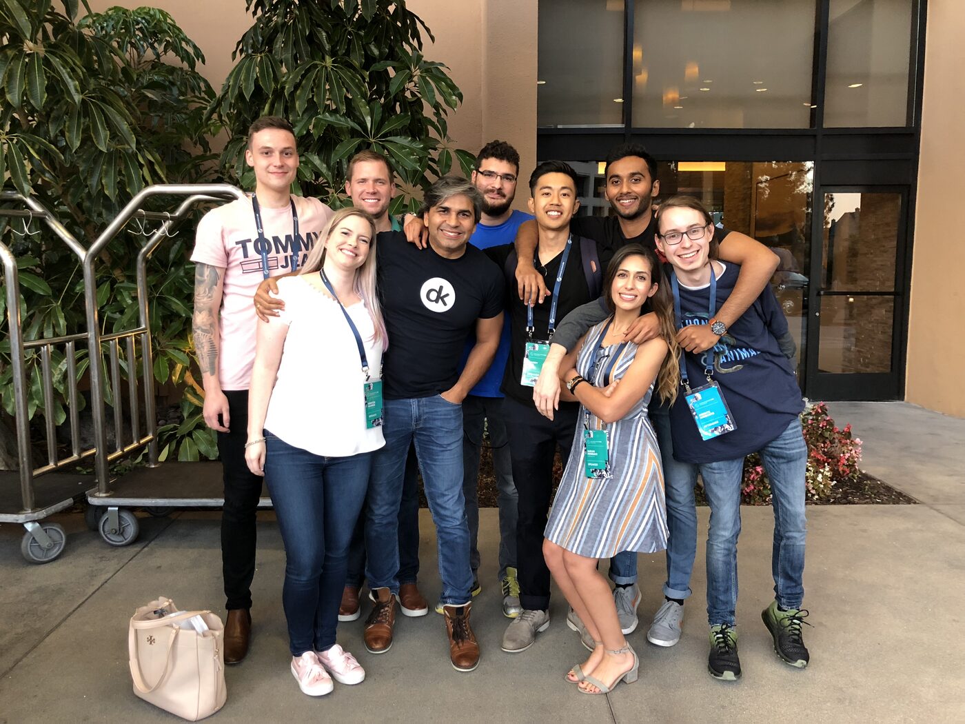 Group photograph of nine speakers and attendees outside the conference hotel entrance in San Diego, still wearing DataScienceGO lanyards and badges.