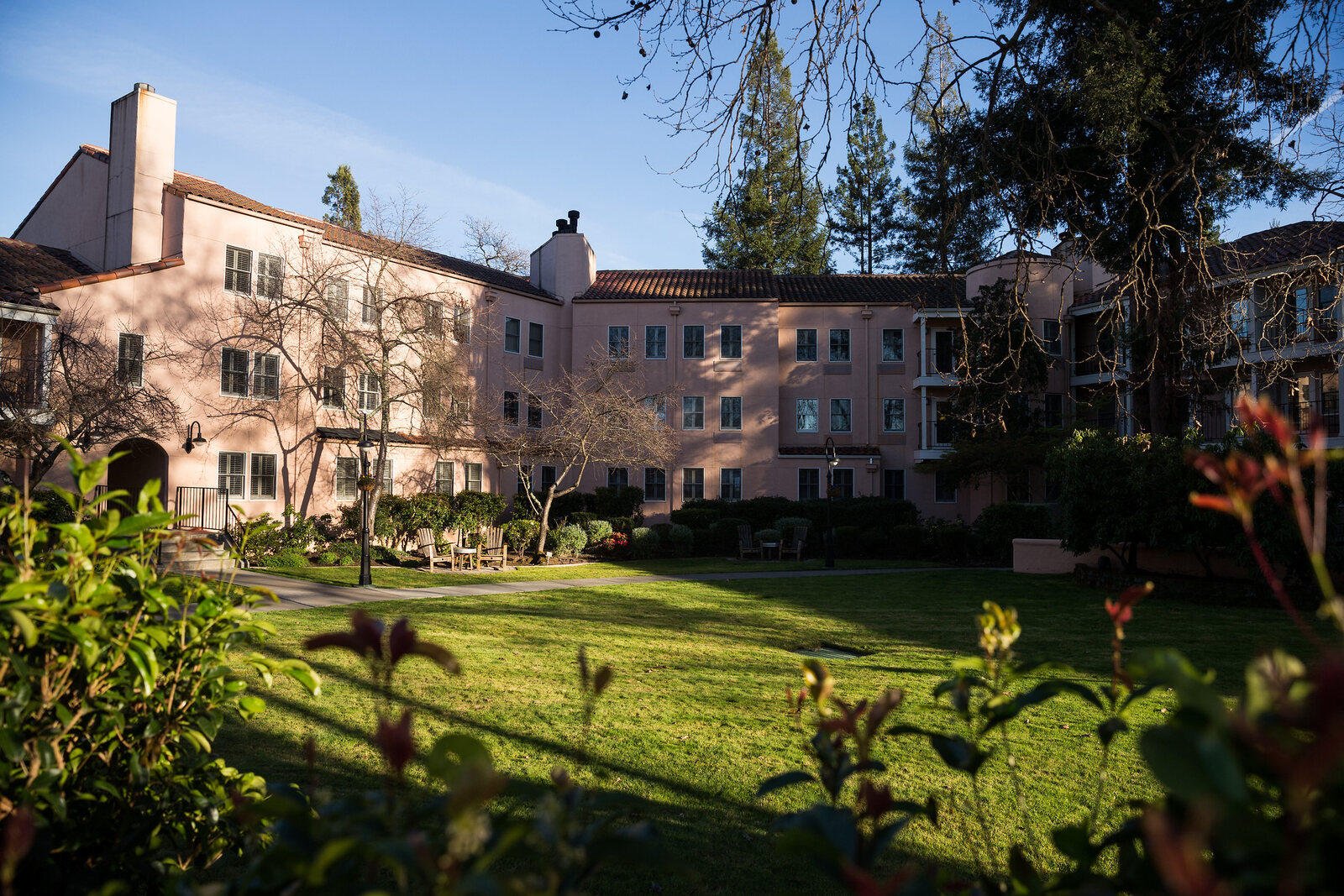 The Fairmont Sonoma Mission Inn at dusk, the low pink building behind lawn and planting.