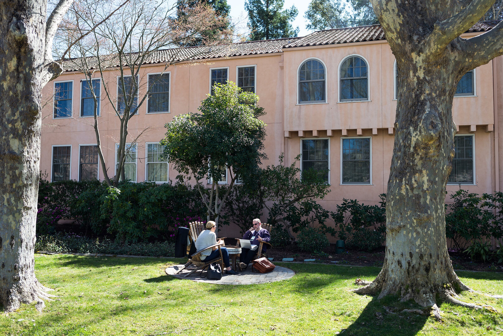 The grounds between sessions, delegates sitting on the lawn under the trees in front of the inn.