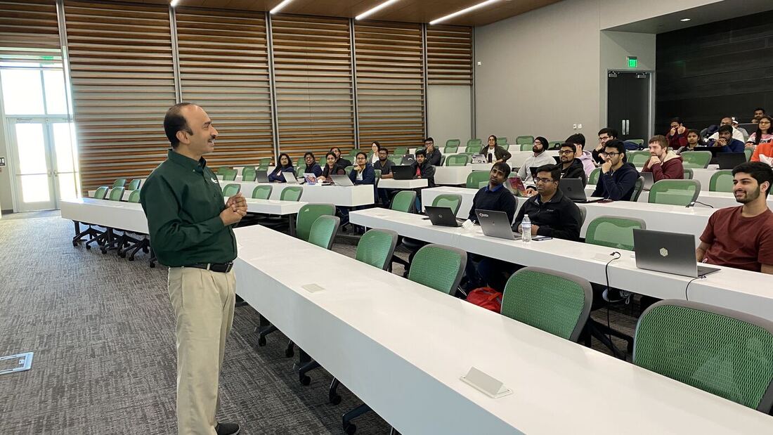 The lecture hall during a session, participants at the benches with laptops open.