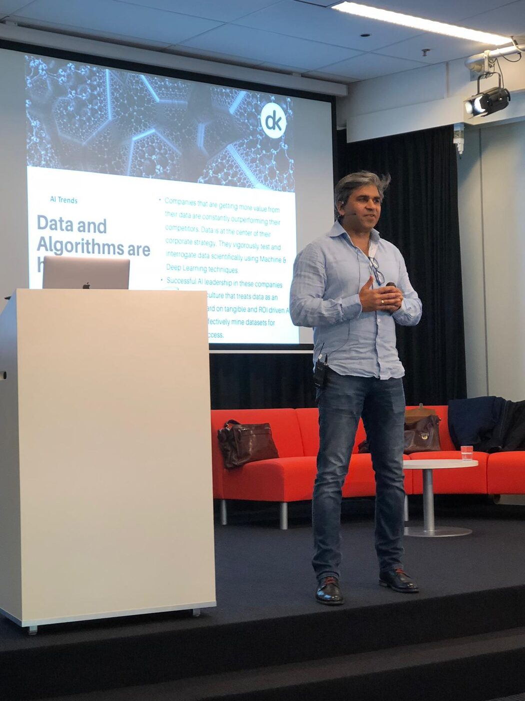 Tarry Singh presents beside the lectern, the screen behind him reading Data and Algorithms are here to stay.